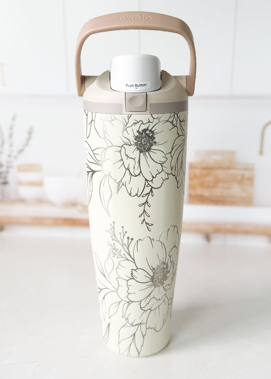 Tumbler with floral design on a white surface
