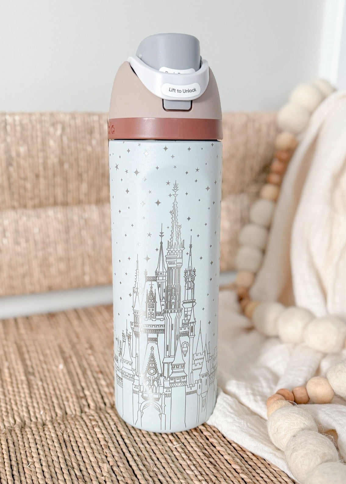 Insulated water bottle with cityscape design on a textured surface